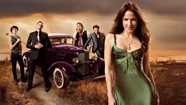Nancy Botwin stands in a field beside a purple vintage car with four companions