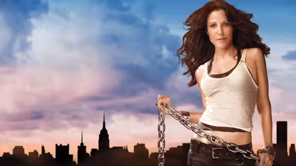 Nancy Botwin holds a heavy chain in front of a city skyline at dusk