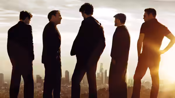 Five men standing in silhouette against the skyline at sunset
