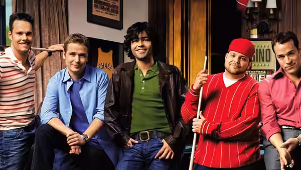 The group posing together inside a bar with one holding a pool cue