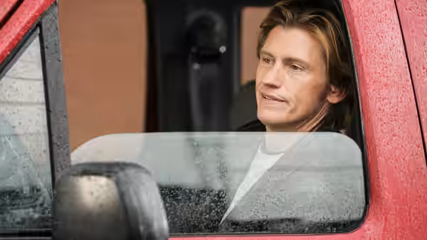 Tommy Gavin (Denis Leary) seated inside a red truck looking sideways