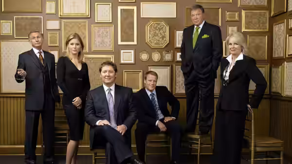 Group of professionals posing together in a room with framed walls