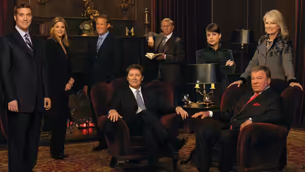 Attorneys in formal wear standing and seated in a lavish office