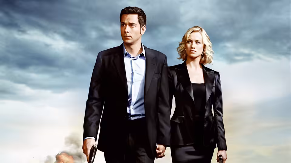 Chuck Bartowski (Zachary Levi) and Sarah Walker (Yvonne Strahovski) walking forward holding guns