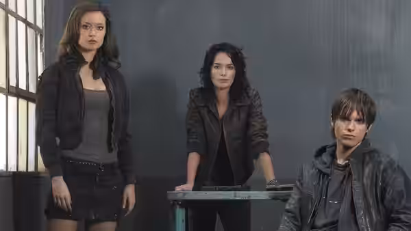 Three young adults standing around a table in a dim room