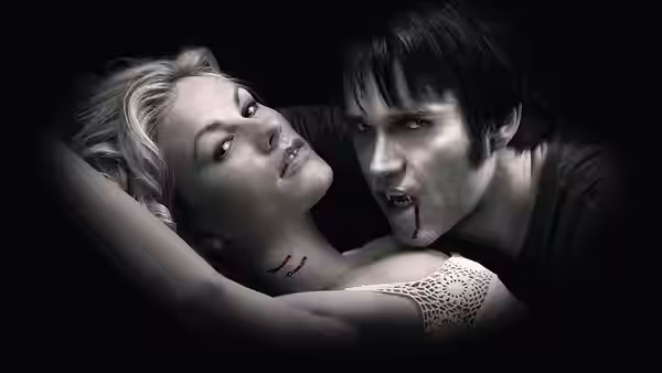 Vampire with blood on his mouth leaning over a blonde woman
