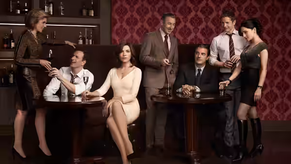 Alicia Florrick (Julianna Margulies) seated with colleagues around bar tables