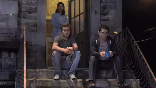 Josh Levison (Sam Huntington) and Aidan Waite (Sam Witwer) sitting on steps with Sally Malik (Meaghan Rath) in doorway
