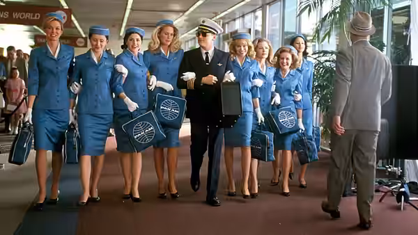 Frank Abagnale Jr. (Leonardo DiCaprio) leading flight attendants through an airport terminal