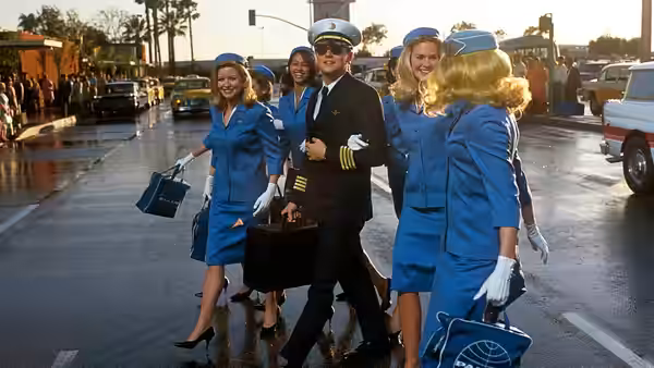 Frank Abagnale Jr. (Leonardo DiCaprio) walking with flight attendants carrying briefcases
