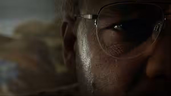 An older man with glasses looking intently toward one side