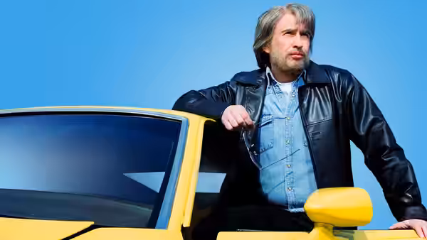 Tommy Saxondale (Steve Coogan) leaning out of a yellow car