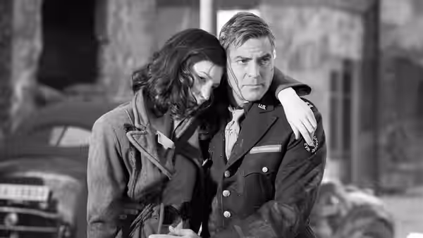 Lena Brandt (Cate Blanchett) and Jake Geismar (George Clooney) embracing by a car