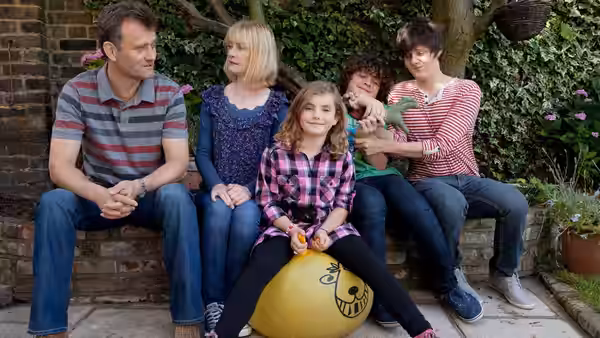 Pete (Hugh Dennis) sits with Sue (Claire Skinner) and children on garden steps