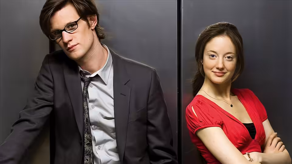 Danny Foster (Matt Smith) and Kirsty MacKenzie (Andrea Riseborough) leaning against a dark wall