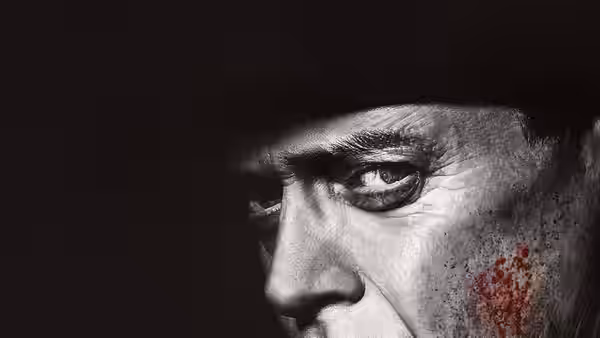 Close-up of a man in a hat with blood on his cheek