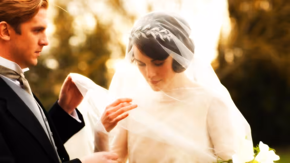 Michelle Dockery as Mary Crawley adjusts her veil beside her groom