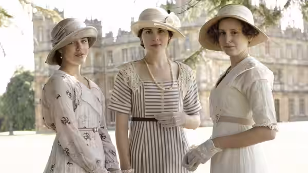 Michelle Dockery as Mary Crawley with two women outside a stately home