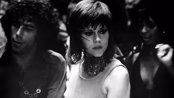 Bree Daniels (Jane Fonda) sits between two people in a crowded club