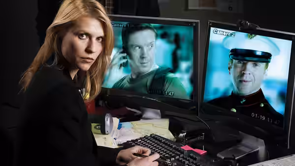 Carrie Mathison (Claire Danes) at a desk monitoring multiple surveillance screens