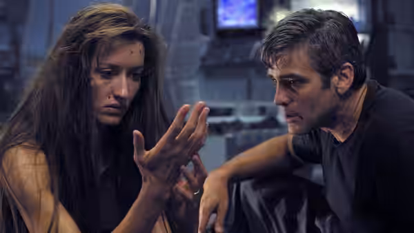 Rheya (Natascha McElhone) gesturing to Chris Kelvin (George Clooney) in dim light