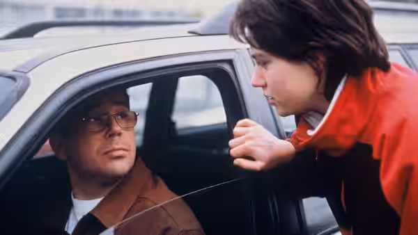 Rosetta (Émilie Dequenne) leans toward a man seated in a car