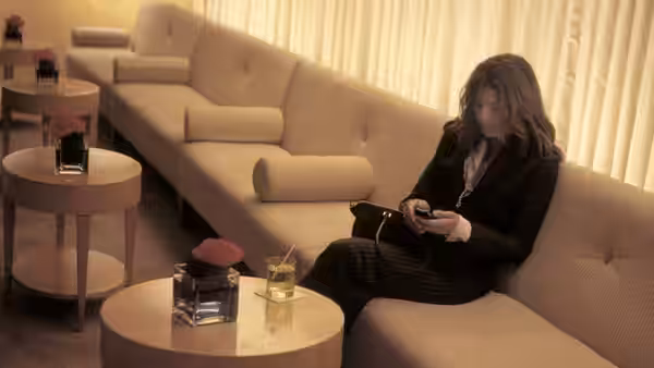 Julia Roberts using a device while seated on a sofa