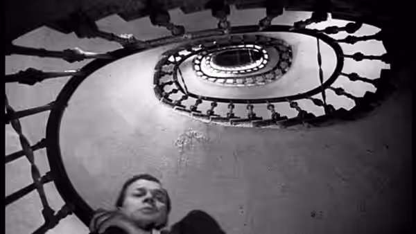 Anna Schmidt (Alida Valli) lies at the base of a spiral staircase