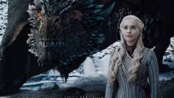 Daenerys Targaryen (Emilia Clarke) standing beside her dragon in snow
