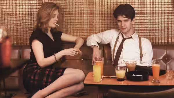 Bel Rowley (Romola Garai) and Freddie Lyon (Ben Whishaw) seated in a booth