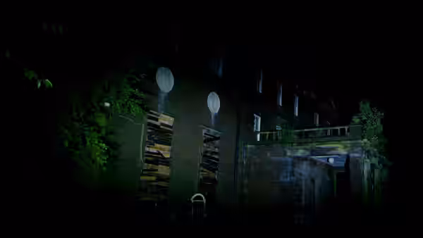Large abandoned building at night with boarded windows and two round lights
