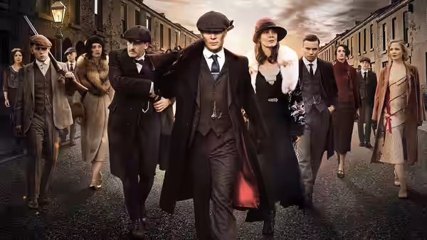 Thomas Shelby leading a large group walking along a city street