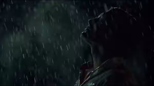 Man tilting his head back under pouring rain at night