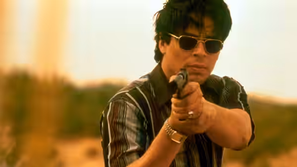 Javier Rodriguez (Benicio del Toro) aiming a pistol forward in daylight