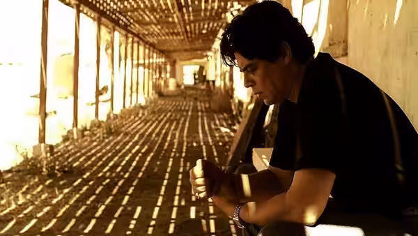 Javier Rodriguez (Benicio del Toro) sitting in a long empty corridor