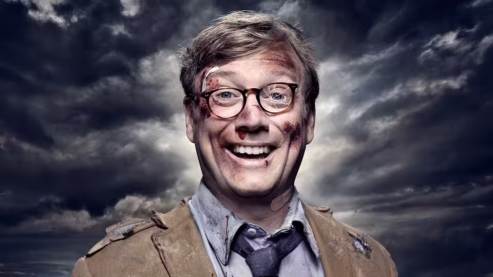 Forrest MacNeil (Andrew Daly) smiles with blood on his face under stormy clouds