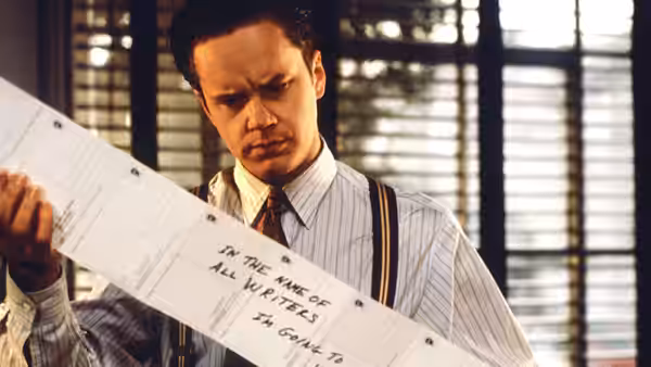 Griffin Mill (Tim Robbins) reading a long printed document in an office