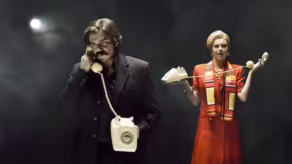 Steven Toast (Matt Berry) speaking into an old telephone beside a woman