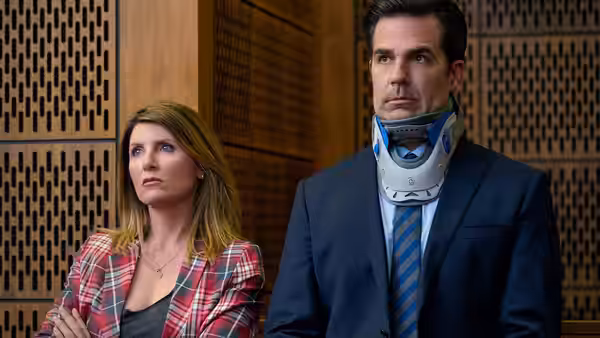 Sharon (Sharon Horgan) and Rob (Rob Delaney) in a neck brace in court