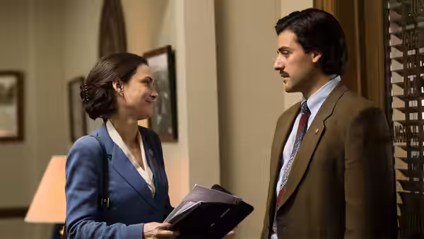 Nick Wasicsko (Oscar Isaac) speaks with a woman in a hallway