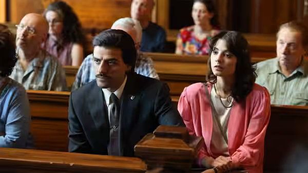 Nick Wasicsko (Oscar Isaac) sits beside a woman in a courtroom
