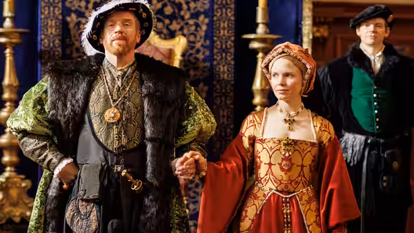 Henry VIII (Damian Lewis) holds hands with Anne Boleyn (Claire Foy) indoors