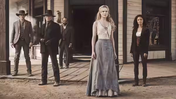A blonde woman in a blue dress stands on a wooden porch before men in a western town