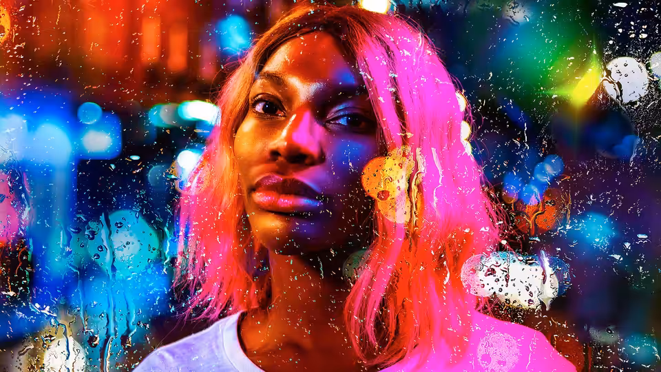 Arabella (Michaela Coel) with pink hair under colorful neon lights