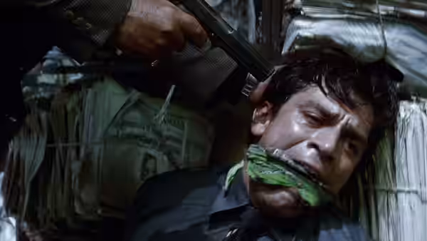Man bound and gagged with a gun held to his head