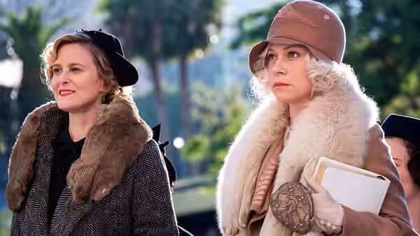 Della Street (Juliet Rylance) and Ginny Aimes (Katherine Waterston) standing side by side outdoors