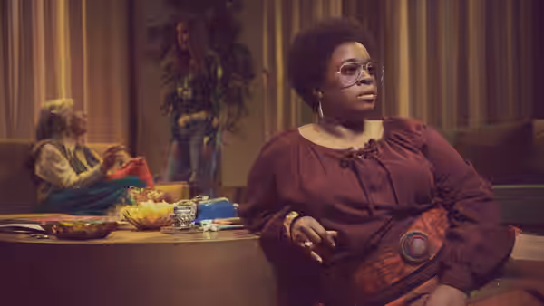 Shirley Chisholm (Uzo Aduba) seated at a table in a lounge