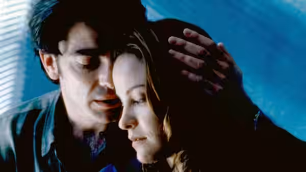 Man and woman lean foreheads together in a close embrace