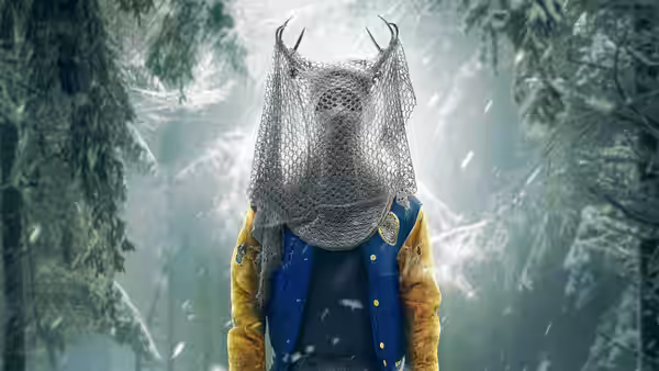 A figure with antlers and chainmail head covering stands in a snowy forest
