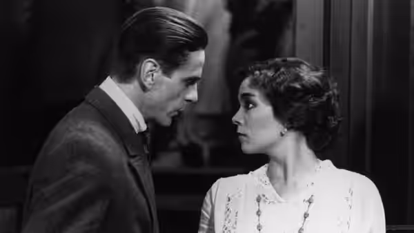 Kafka (Jeremy Irons) and Gabriela (Theresa Russell) facing each other indoors